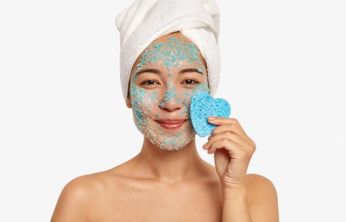 A woman exfoliating her face 