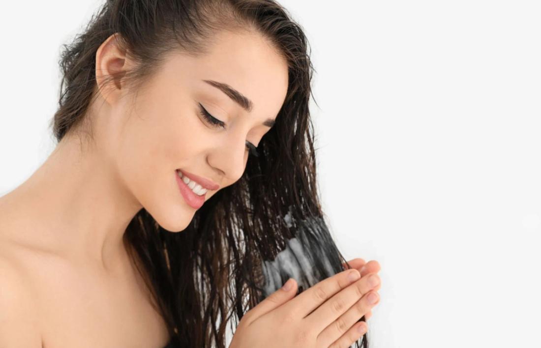A woman applying conditioner on her hair