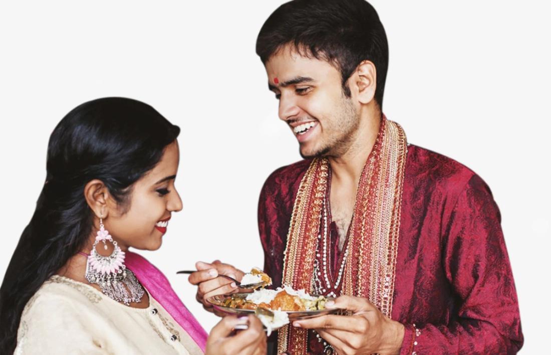 A husband giving sweets to her wife after completing her fast of karwa chauth